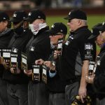 The umpire crew participate a "Stand Up to Cancer" moment during in Game 3 of the baseball World Series between the Los Angeles Dodgers and the Tampa Bay Rays Friday, Oct. 23, 2020, in Arlington, Texas. (AP Photo/Eric Gay)