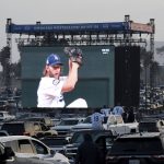 Clayton Kershaw of the Los Angeles Dodgers pitches as fans look on a giant screen during game one of the World Series between the Tampa Bay Rays and the Los Angeles Dodgers in the parking lot of Dodger Stadium in Los Angeles on Tuesday, October 20, 2020. (Keith Birmingham/The Orange County Register via AP)