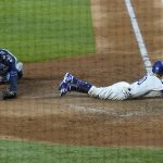 Los Angeles Dodgers' Mookie Betts scores past Tampa Bay Rays catcher Mike Zunino on a fielders choice by Max Muncy during the fifth inning in Game 1 of the baseball World Series Tuesday, Oct. 20, 2020, in Arlington, Texas. (AP Photo/Eric Gay)