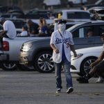 Baseball fans sit in their cars outside Dodger Stadium and watch the television broadcast of Game 1 of the 2020 World Series between the Los Angeles Dodgers and the Tampa Bay Rays in Tuesday, Oct. 20, 2020, in Los Angeles. Due to the spread of COVID-19, all of the 2020 World Series games will be played in Arlington, Texas. (AP Photo/Ashley Landis)