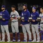 The Los Angeles Dodgers participate a "Stand Up to Cancer" moment during in Game 3 of the baseball World Series against the Tampa Bay Rays Friday, Oct. 23, 2020, in Arlington, Texas. (AP Photo/Tony Gutierrez)