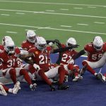 Members of the Arizona Cardinals defense act out a bowling pin strike dramatization after being hit by a ball rolled by Byron Murphy Jr. who intercepted a Dallas Cowboys quarterback Andy Dalton pass in the second half of an NFL football game in Arlington, Texas, Monday, Oct. 19, 2020. (AP Photo/Ron Jenkins)