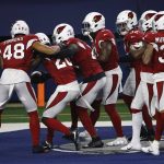Arizona Cardinals' Isaiah Simmons (48) and others celebrate with Dre Kirkpatrick, second from left, after Kirkpatrick intercepted a pass thrown by Dallas Cowboys' Andy Dalton in the second half of an NFL football game in Arlington, Texas, Monday, Oct. 19, 2020. (AP Photo/Ron Jenkins)