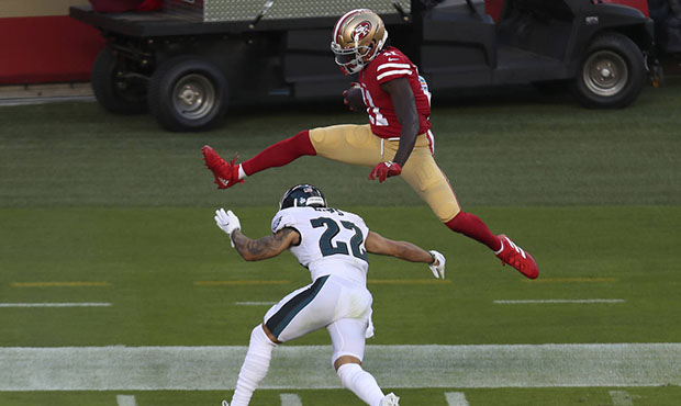 San Francisco 49ers wide receiver Brandon Aiyuk, top, jumps over Philadelphia Eagles safety Marcus ...