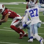 Arizona Cardinals wide receiver Larry Fitzgerald fights for a first down after catching a pass as Dallas Cowboys cornerback Trevon Diggs (27) helps make the stop in the first half of an NFL football game in Arlington, Texas, Monday, Oct. 19, 2020. (AP Photo/Michael Ainsworth)