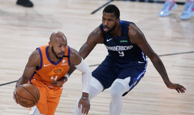 Phoenix Suns' Jevon Carter (4) drives past Dallas Mavericks' Michael Kidd-Gilchrist (9) during the ...