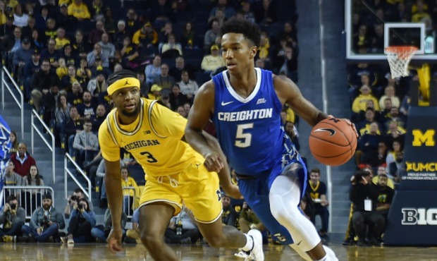 Ty-Shon Alexander #5 of the Creighton Bluejays dribbles past Zavier Simpson #3 of the Michigan Wolv...