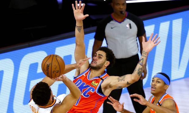 Phoenix Suns' Devin Booker, left, tries to shoot past Oklahoma City Thunder's Abdel Nader, center, ...