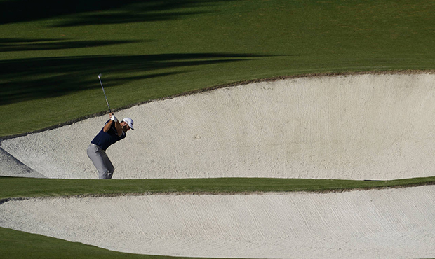 Dustin Johnson hits out of a bunker on the eighth hole during the second round of the Masters golf ...