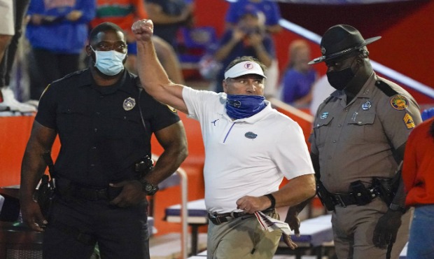 Florida head coach Dan Mullen, center, raises his fist to cheering Florida fans after an argument a...