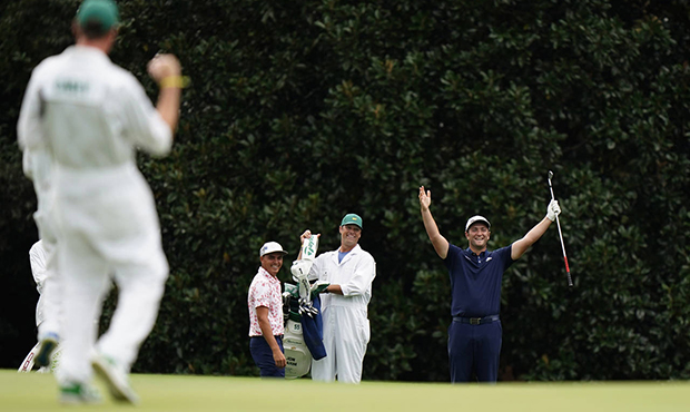 Rickie Fowler, left, watches as Jon Rahm, of Spain, celebrates chipping into the hole on eat 16th g...