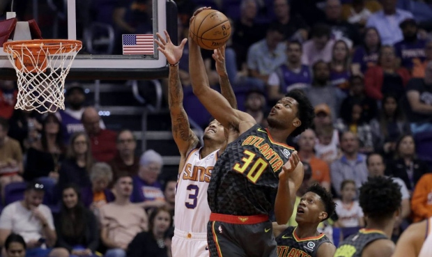 Atlanta Hawks center Damian Jones (30) rebounds over Phoenix Suns forward Kelly Oubre Jr. (3) durin...