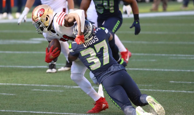 Brandon Aiyuk #11 of the San Francisco 49ers is hit by Quandre Diggs #37 of the Seattle Seahawks in...