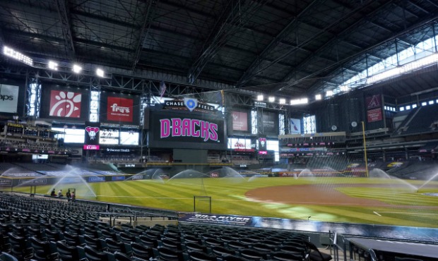 The grounds crew waters the Chase Field after the Colorado Rockies decided not to play their baseba...