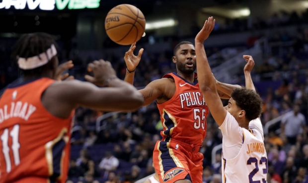 New Orleans Pelicans guard E'Twaun Moore (55) dishes off to guard Jrue Holiday (11) as Phoenix Suns...