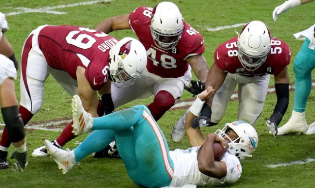 Miami Dolphins quarterback Tua Tagovailoa (1) slide before being hit by Arizona Cardinals middle li...