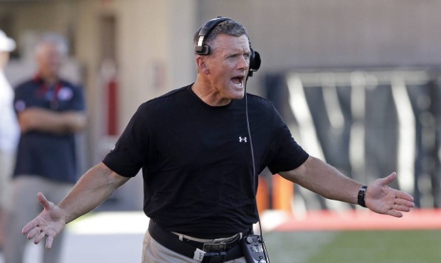 In this Aug. 28, 2014, file photo, Utah coach Kyle Whittingham shouts as he runs onto the field dur...
