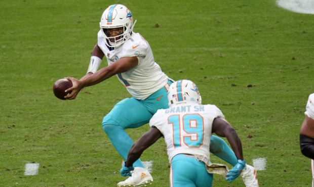 Miami Dolphins quarterback Tua Tagovailoa (1) fakes a hand off to wide receiver Jakeem Grant (19) d...