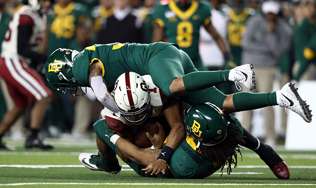 WACO, TEXAS - NOVEMBER 16:  Jalen Hurts #1 of the Oklahoma Sooners is tackled by Chris Miller #3 an...