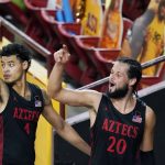 San Diego State's Jordan Schakel (20) and Trey Pulliam (4) wave to the few San Diego State fans in attendance after the team's NCAA college basketball game against Arizona State Thursday, Dec. 10, 2020, in Tempe, Ariz. San Diego State won 80-68. (AP Photo/Ross D. Franklin)