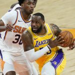 Los Angeles Lakers forward LeBron James (23) drives past Phoenix Suns center Damian Jones (30) during the first half of a preseason basketball game, Friday, Dec. 18, 2020, in Phoenix, Ariz. (AP Photo/Matt York)