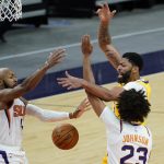 Los Angeles Lakers forward Anthony Davis, right, loses the ball under pressure from Phoenix Suns forward Cameron Johnson (23) and guard Jevon Carter during the first half of a preseason basketball game, Friday, Dec. 18, 2020, in Phoenix, Ariz. (AP Photo/Matt York)