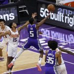 Sacramento Kings guard De'Aaron Fox (5) goes to the basket past Phoenix Suns guard Cameron Payne (15) during the second half of an NBA basketball game in Sacramento, Calif., Saturday, Dec. 26, 2020. The Kings won 106-103. (AP Photo/Rich Pedroncelli)