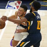 Utah Jazz guard Mike Conley (10) fouls Phoenix Suns guard Devin Booker during the second half of an NBA basketball game Thursday, Dec. 31, 2020, in Salt Lake City. (AP Photo/Rick Bowmer)