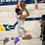 Phoenix Suns guard Devin Booker shoots as Utah Jazz's Royce O'Neale (23) and Rudy Gobert (27) watch during the second half of an NBA basketball game Thursday, Dec. 31, 2020, in Salt Lake City. (AP Photo/Rick Bowmer)