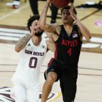 San Diego State guard Trey Pulliam (4) drives past Arizona State guard Holland Woods (0) during the second half of an NCAA college basketball game Thursday, Dec. 10, 2020, in Tempe, Ariz. (AP Photo/Ross D. Franklin)