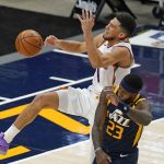 Utah Jazz forward Royce O'Neale (23) fouls Phoenix Suns guard Devin Booker (1) during the first half of an NBA basketball game Thursday, Dec. 31, 2020, in Salt Lake City. (AP Photo/Rick Bowmer)