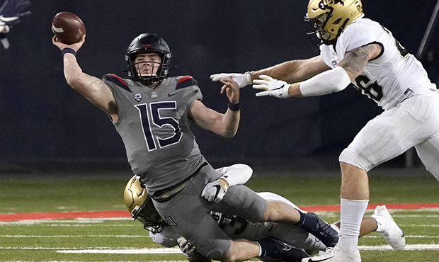 Arizona quarterback Will Plummer (15) gets pressured by Colorado safety Isaiah Lewis and Chase Newm...