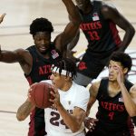 San Diego State forward Nathan Mensah, left, and guard Trey Pulliam (4) defend against Arizona State forward Jalen Graham, front, during the first half of an NCAA college basketball game Thursday, Dec. 10, 2020, in Tempe, Ariz. (AP Photo/Ross D. Franklin)
