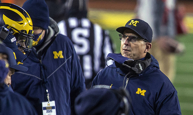 Michigan coach Jim Harbaugh stands on the sideline during the first quarter of the team's NCAA coll...