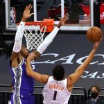 Phoenix Suns guard Devin Booker, right, goes to the basket against Sacramento Kings center Richaun Holmes during the first quarter of an NBA basketball game in Sacramento, Calif., Saturday, Dec. 26, 2020. (AP Photo/Rich Pedroncelli)