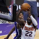 Phoenix Suns center Deandre Ayton, right, goes to the basket against Sacramento Kings guard Buddy Hield during the second half of an NBA basketball game in Sacramento, Calif., Saturday, Dec. 26, 2020. The Kings won 106-103. (AP Photo/Rich Pedroncelli)