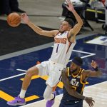 Utah Jazz forward Royce O'Neale, right, fouls Phoenix Suns guard Devin Booker (1) during the first half of an NBA basketball game Thursday, Dec. 31, 2020, in Salt Lake City. (AP Photo/Rick Bowmer)