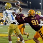 UCLA quarterback Dorian Thompson-Robinson (1) intentionally grounds the football in the end zone for a safety as Arizona State defensive end Michael Matus (91) defends during the second half of an NCAA college football game, Sunday, Dec. 6, 2020, in Tempe, Ariz. UCLA won 25-18. (AP Photo/Matt York)