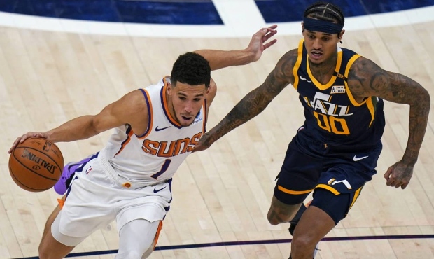 Phoenix Suns guard Devin Booker (1) drives around Utah Jazz guard Jordan Clarkson (00) during the s...