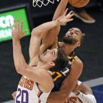 Utah Jazz center Rudy Gobert, rear, blocks the shot of Phoenix Suns forward Dario Saric (20) during the first half of an NBA basketball game Thursday, Dec. 31, 2020, in Salt Lake City. (AP Photo/Rick Bowmer)