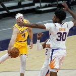 Los Angeles Lakers guard Alex Caruso (4) dishes off around Phoenix Suns center Damian Jones (30) during the first half of a preseason basketball game, Friday, Dec. 18, 2020, in Phoenix, Ariz. (AP Photo/Matt York)
