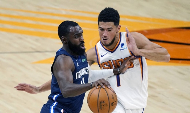 Dallas Mavericks guard Tim Hardaway Jr. drives past Phoenix Suns guard Devin Booker (1) during the ...