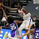 Sacramento Kings forward Marvin Bagley IIIl, left, has his shot blocked by Phoenix Suns center Deandre Ayton during the second half of an NBA basketball game in Sacramento, Calif., Saturday, Dec. 26, 2020. The Kings won 106-103. (AP Photo/Rich Pedroncelli)