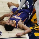 Phoenix Suns' Abdel Nader lies on the court after a hard foul from Utah Jazz center Udoka Azubuike (20) during the second half of an NBA preseason basketball game, Monday, Dec. 14, 2020, in Salt Lake City. Azubuike was ejected from the game after being issued a Flagrant-2 foul. (AP Photo/Rick Bowmer)