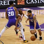 Phoenix Suns guard Chris Paul, center, tries to squeeze past a pick set by Sacramento Kings center Hassan Whiteside, left, as Kings' Cory Joseph drives during the first quarter of an NBA basketball game in Sacramento, Calif., Saturday, Dec. 26, 2020. (AP Photo/Rich Pedroncelli)