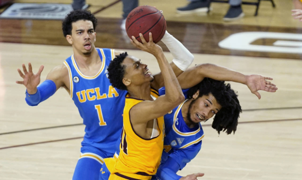 Arizona State guard Alonzo Verge Jr., middle, tries to get off a shot as UCLA guard Tyger Campbell,...