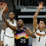 Phoenix Suns forward Mikal Bridges (25) drives past Denver Nuggets forward Michael Porter Jr. (1) during the second half of an NBA basketball game Saturday, Jan. 23, 2021, in Phoenix. (AP Photo/Rick Scuteri)