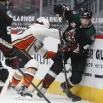 Anaheim Ducks' Sam Steel (23) shoves Arizona Coyotes' Jordan Oesterle ((82) into the boards during the first period of an NHL hockey game Thursday, Jan. 28, 2021, in Glendale, Ariz. (AP Photo/Darryl Webb)