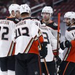 Anaheim Ducks' players Jacob Larsson (32), Danton Heinen (43), Ben Hutton (7) and Adam Henrique (14) surround Jakob Silfverberg (33) after his goal against the Arizona Coyotes during the first period of an NHL hockey game Thursday, Jan. 28, 2021, in Glendale, Ariz. (AP Photo/Darryl Webb)