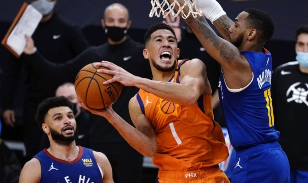 Phoenix Suns guard Devin Booker (1) drives between Denver Nuggets guard Jamal Murray and Monte Morr...